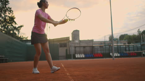 Slow-motion:-Young-Caucasian-teenager-female-tennis-player-serving-during-a-game-or-practice.-Tennis-Player-Serving-On-The-Clay-Court.